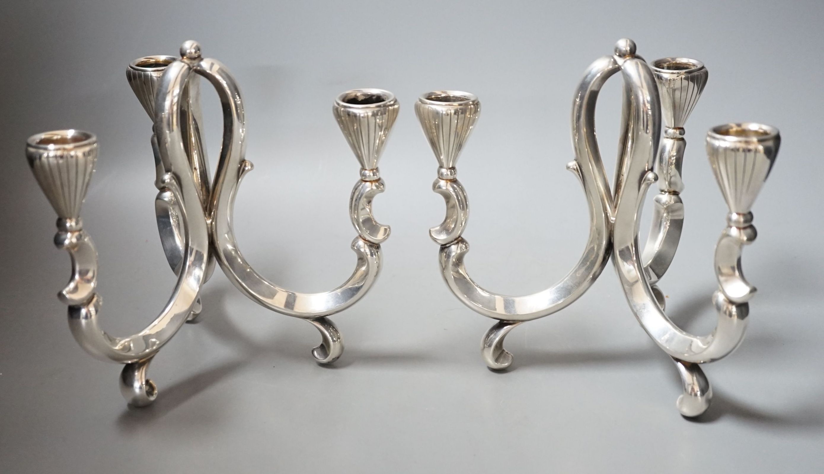 A pair of early 20th century German 835 white metal three light scroll arm candelabra, by Lutz & Weiss, height 18cm